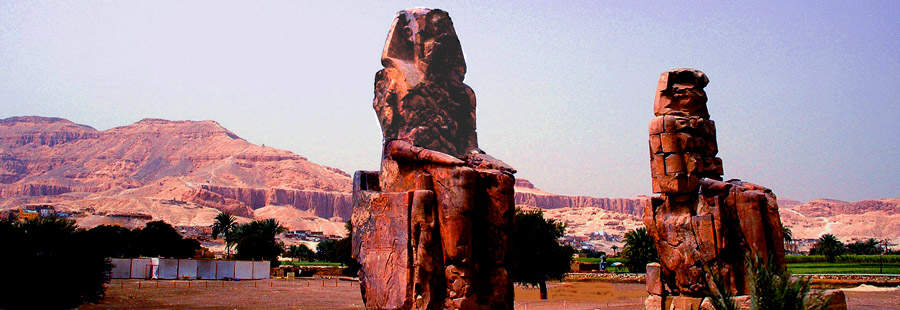 GREAT STATUES AT THE NILE BRIDGE - VALLEY OF KINGS IN THE BACKGROUND